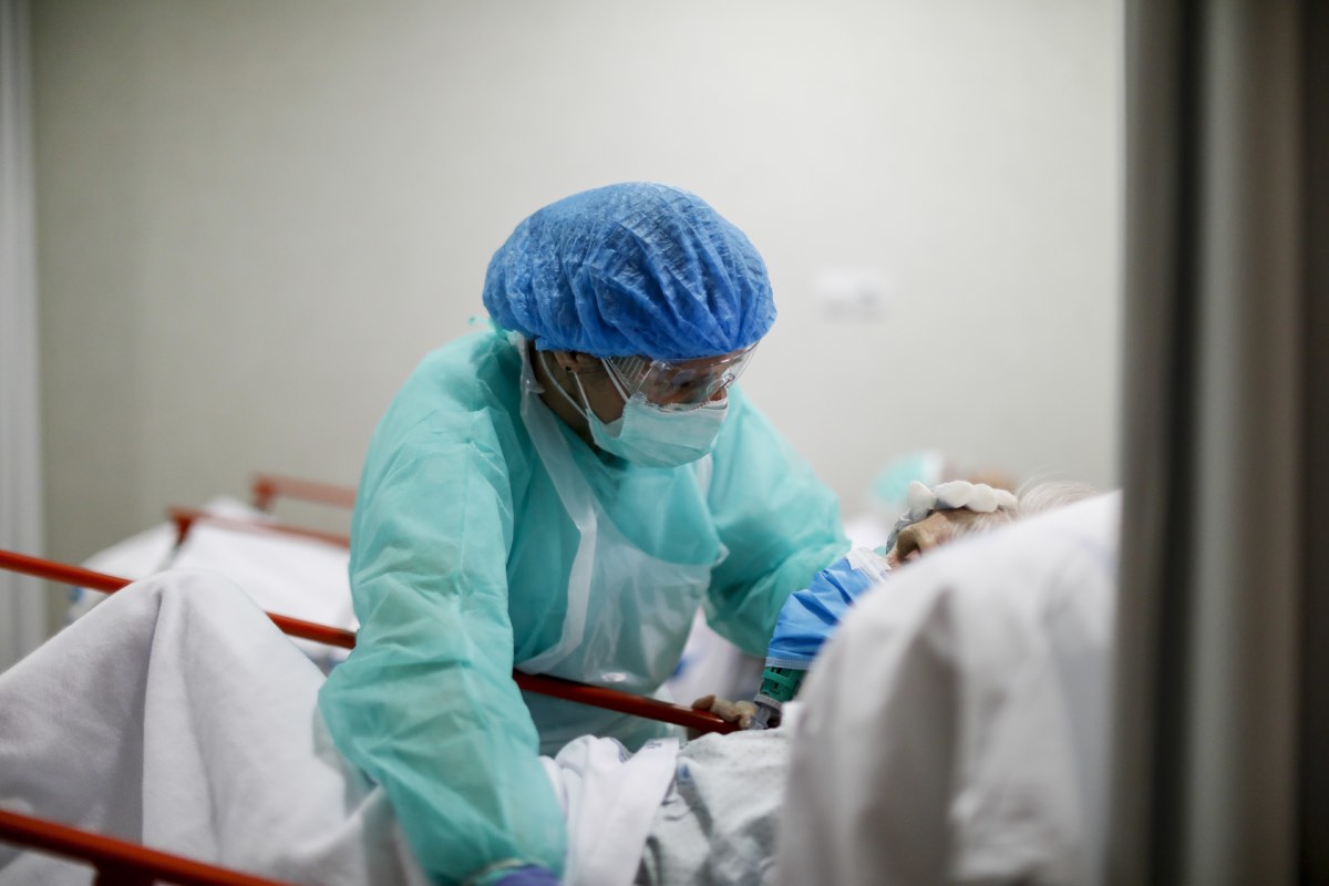 Una doctora reconforta a un paciente aquejado de coronavirus en el Servicio de Urgencias de un hospital de Madrid (FOTO: Alberto Di Lolli).